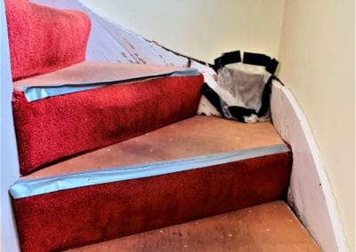 Flight of stairs with cracks in the wall, ready for retrofitting.